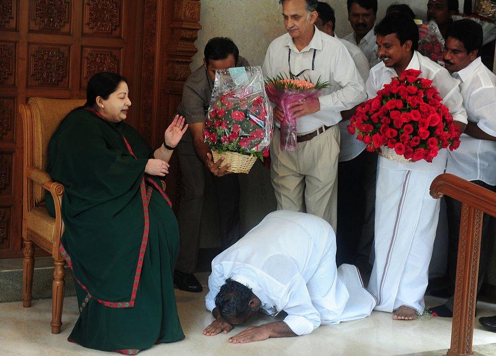 A party cadre prostrates himself at the feet of All India Anna Dravida Munnetra Kazhagam(AIADMK) leader Jayalalithaa Jayaram as she gestures at her residence in Chennai on May 19, 2016.