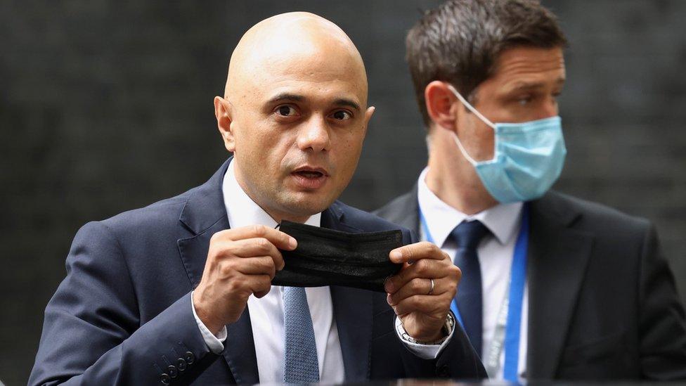 Sajid Javid holding a face mask