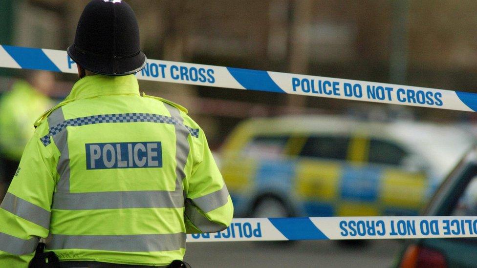 A police officer (in high visibility yellow jacket) stands in front of crime scene tape on Lenton Boulevard in Nottingham, Tuesday February 14, 2006.