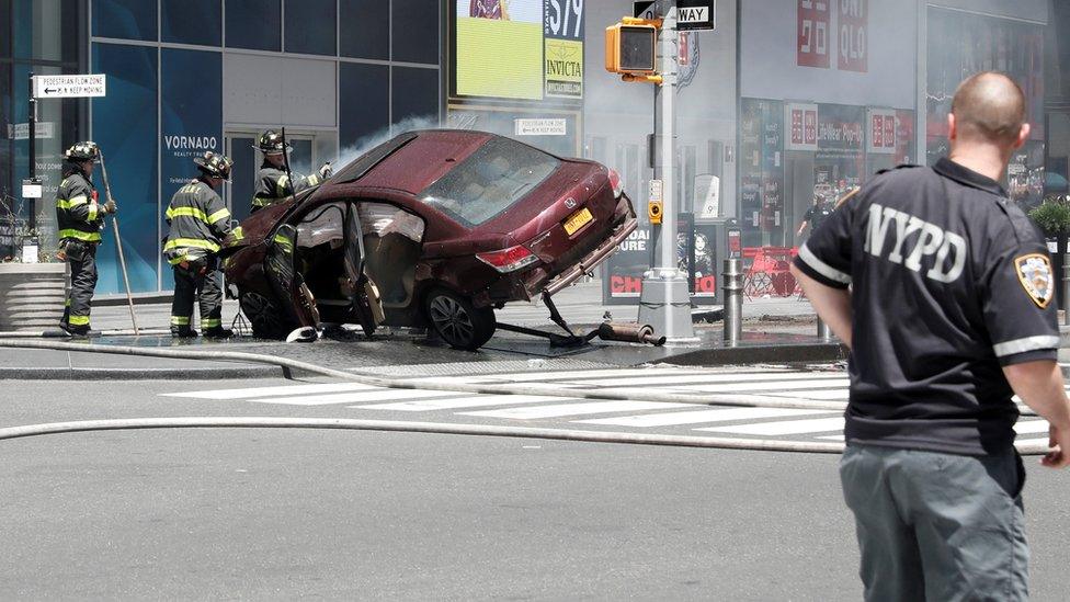 A red car is tilted on its side after striking pedestrians in New York