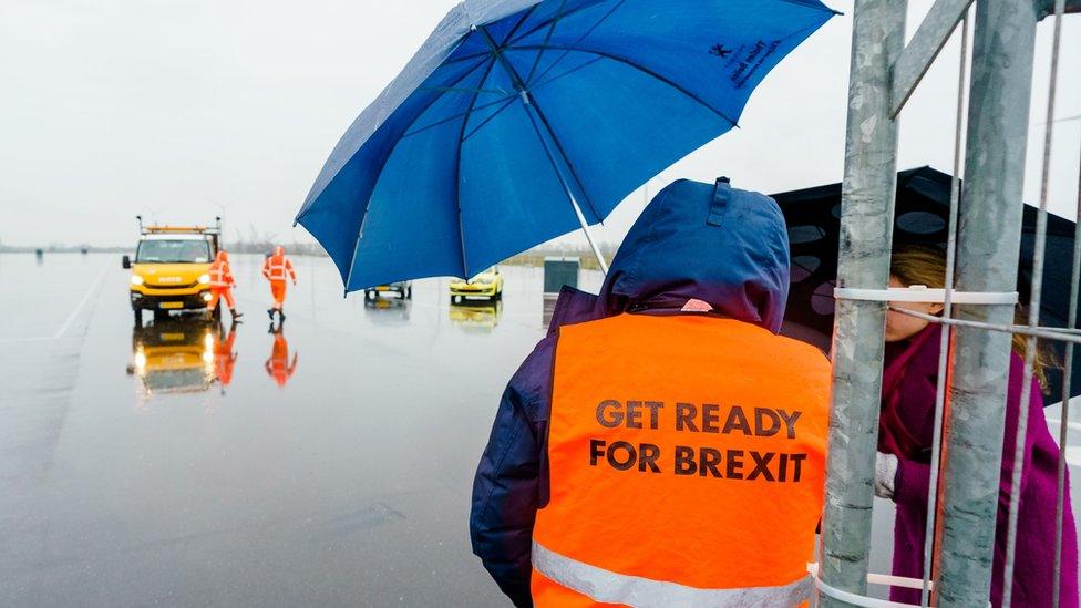 Worker wearing an orange high viz vest, which says "Get Ready For Brexit" on the back