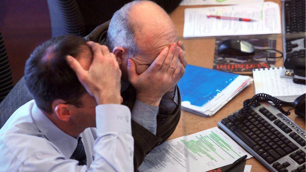 Businessmen sit with the heads in their hands