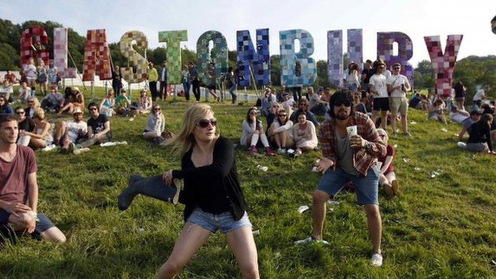 Festival-goers play a game, batting a beer can with a Wellington boot, on the first day of the Glastonbury music festival at Worthy Farm in Somerset, in this June 27, 2013