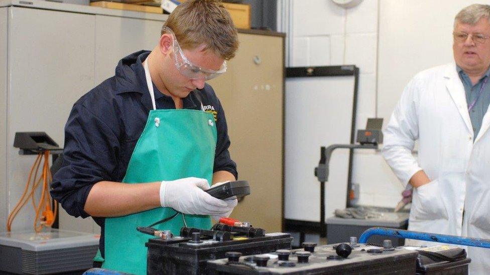 Young man with car batteries