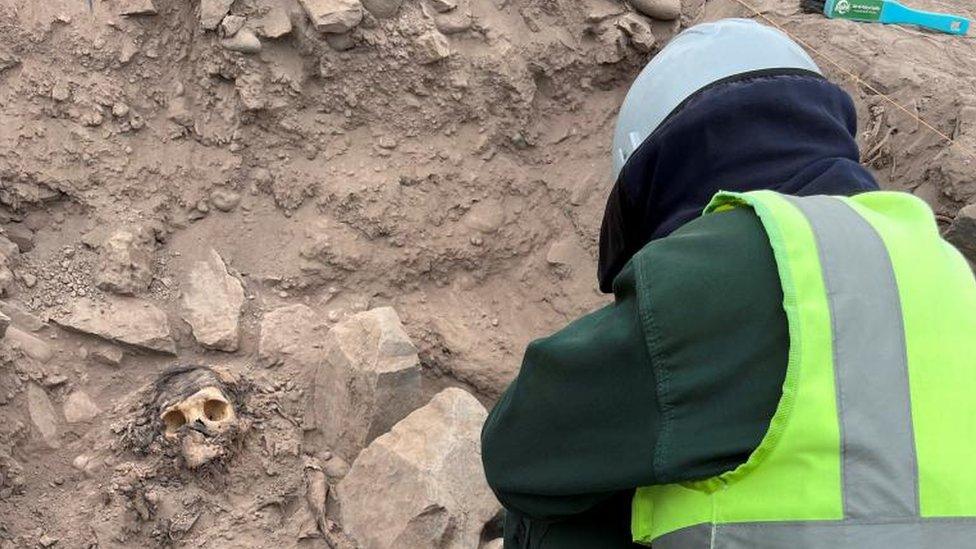 An archaeologist works at the excavation site of a pre-Hispanic burial next to a mummy believed to be from the Manchay culture, which developed in the valleys of Lima between 1,500 and 1,000 BCE, in Lima, Peru, June 14, 2023.