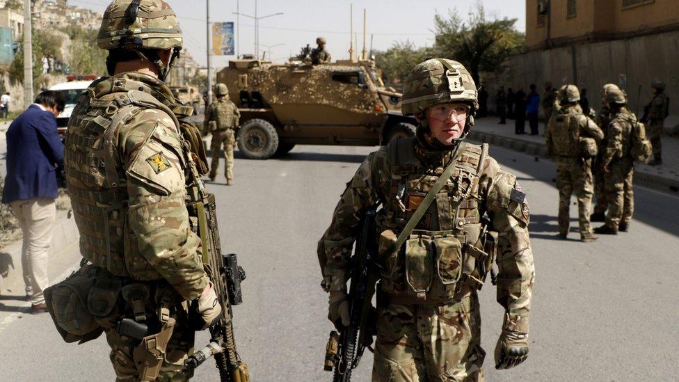 NATO soldiers inspect the scene of a suicide bomb attack in Kabul, Afghanistan, 11 October 2015