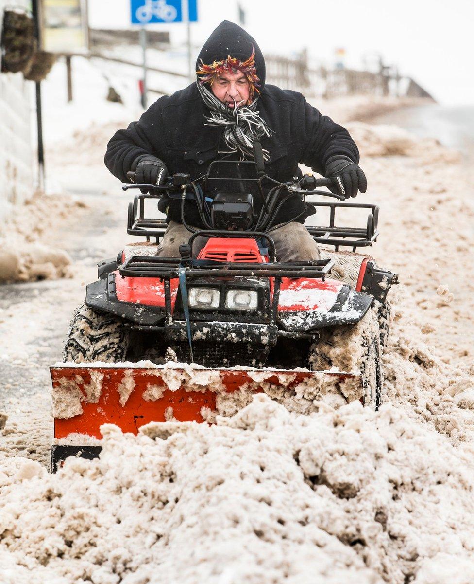 A man clears snow near Blackstone Edge in the Pennines