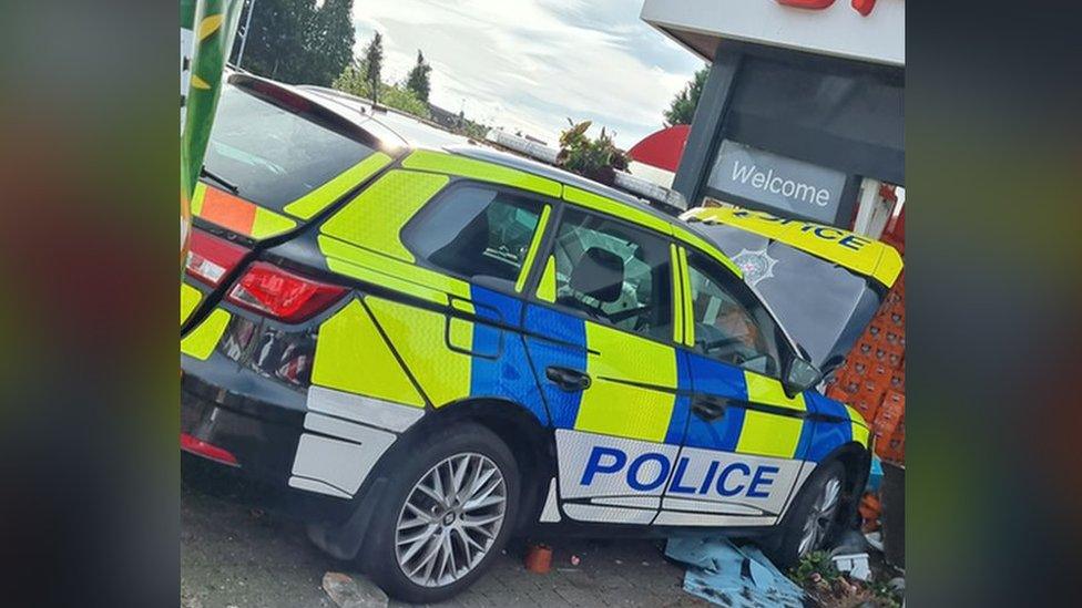 The damaged police car wedged into the front of the Spar shop