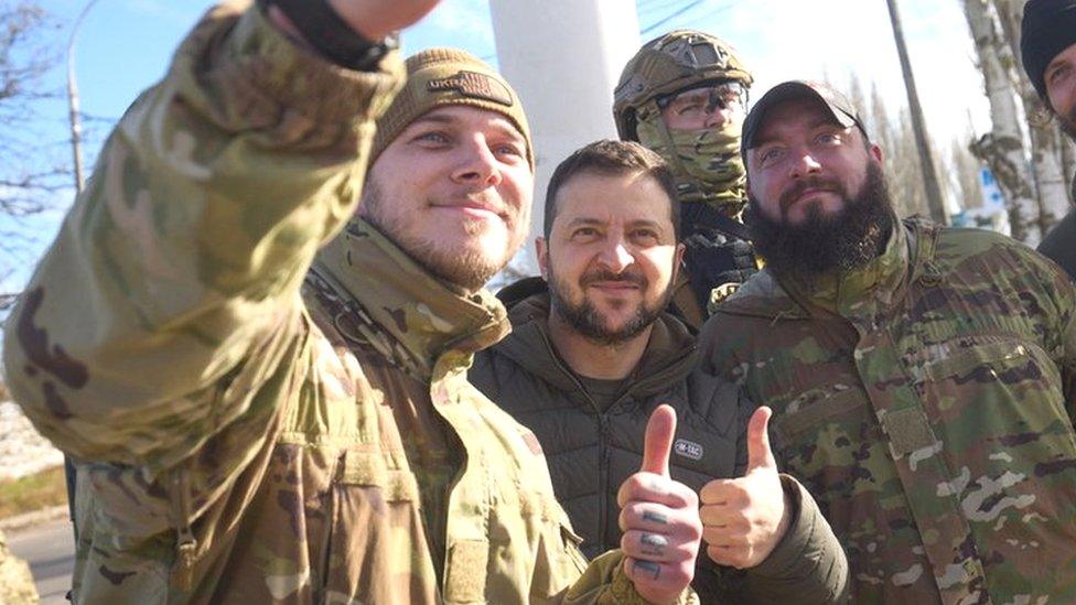 The president poses for a picture with soldiers