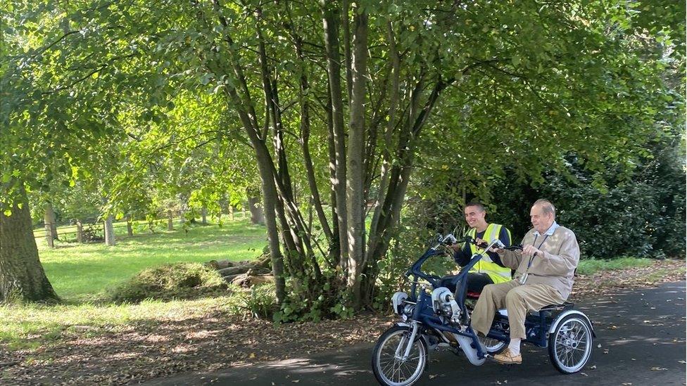 Two people on a tricycle