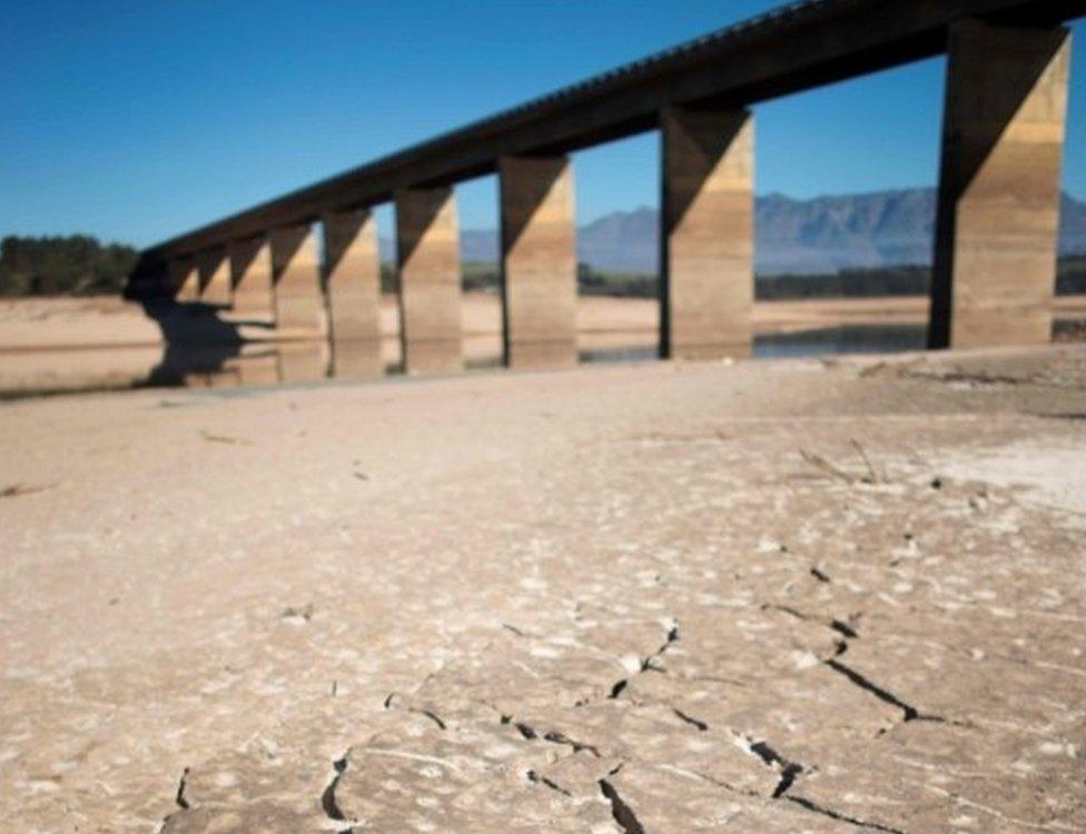 A picture taken on May 10, 2017 shows dry cracked mud staring out at the sky at Theewaterskloof Dam