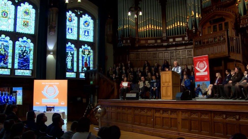 It shows people attending a ceremony at the main hall in the Guildhall