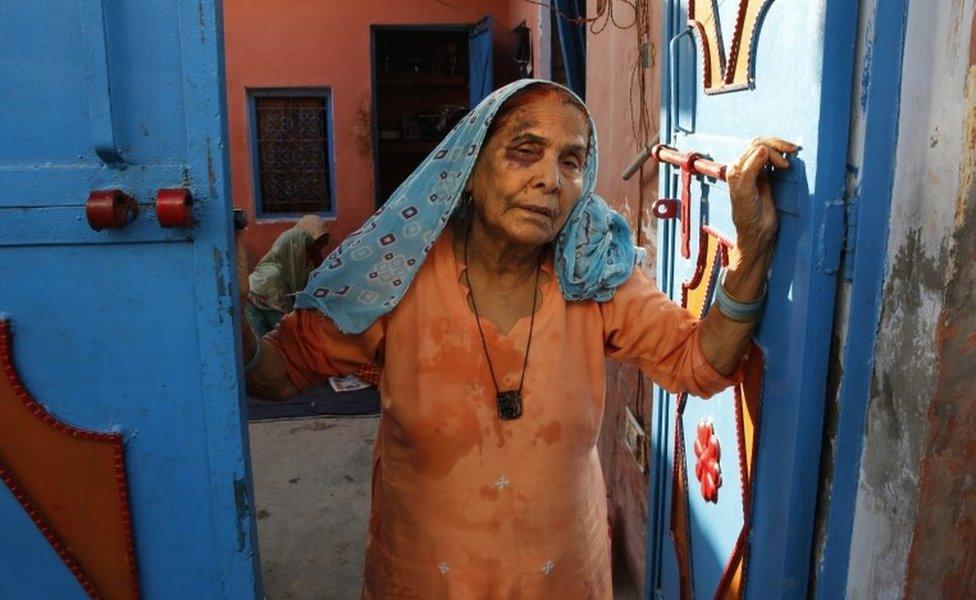 A bruised Asgari Begum, mother of 52-year-old Muslim farmer Mohammad Akhlaq, stands by the entrance of her home in Bisada