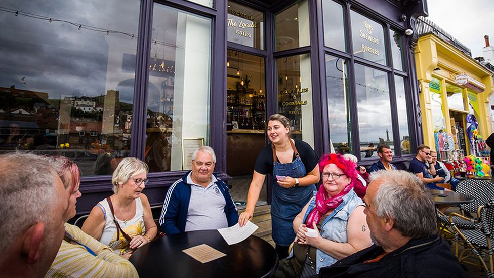 A group sits outside a bar and restaurant in Whitby