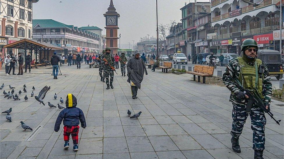 Indian paramilitary personnel patrol along a road in Srinagar on December 11, 2023, ahead of Supreme Court's verdict on Article 370.