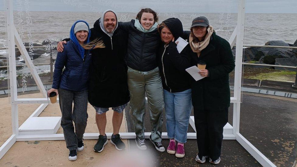 Georgia McManus, centre, with fellow Foo Fighters fans Rachel, Jeff Payne, Suzy James and Jess Ellis. Pictured in front of a clear sign, with the sea behind them