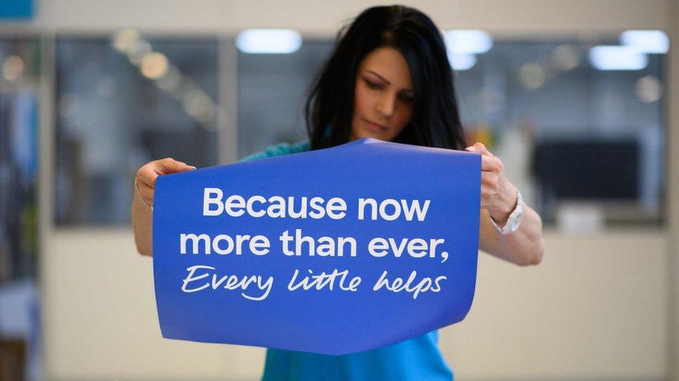 Woman fixes Tesco slogan to protective screen