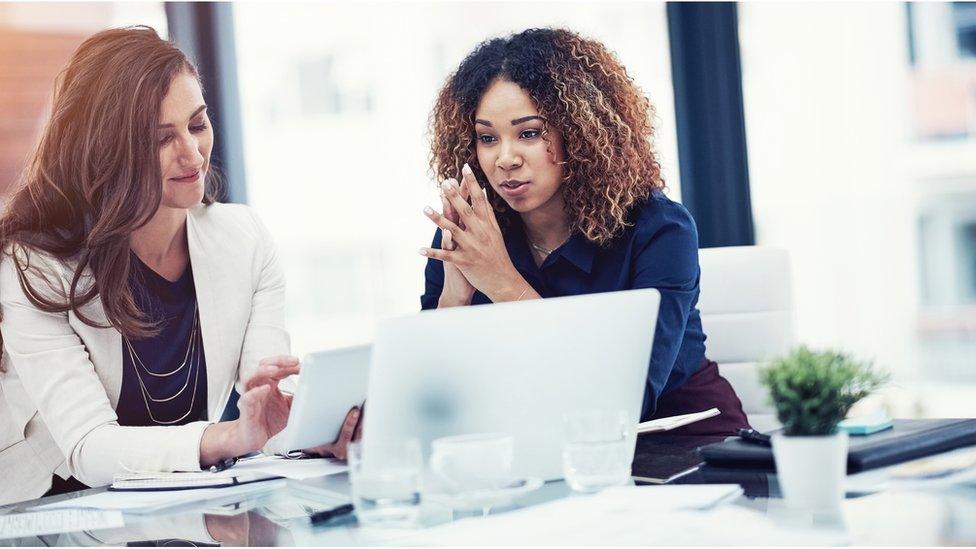 White woman and black woman in office (file picture)