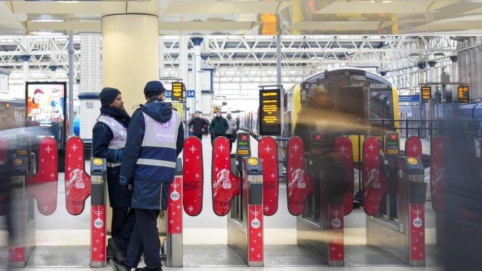 Workers stand at Waterloo Station as rail workers strike over pay and terms, in London, Britain December 13, 2022.