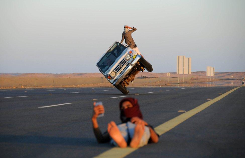 Saudi men perform a stunt known as "sidewall skiing"