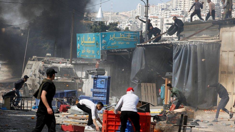 Palestinians throw objects at Israeli forces during a raid in Nablus, in the occupied West Bank, on 22 February 2023