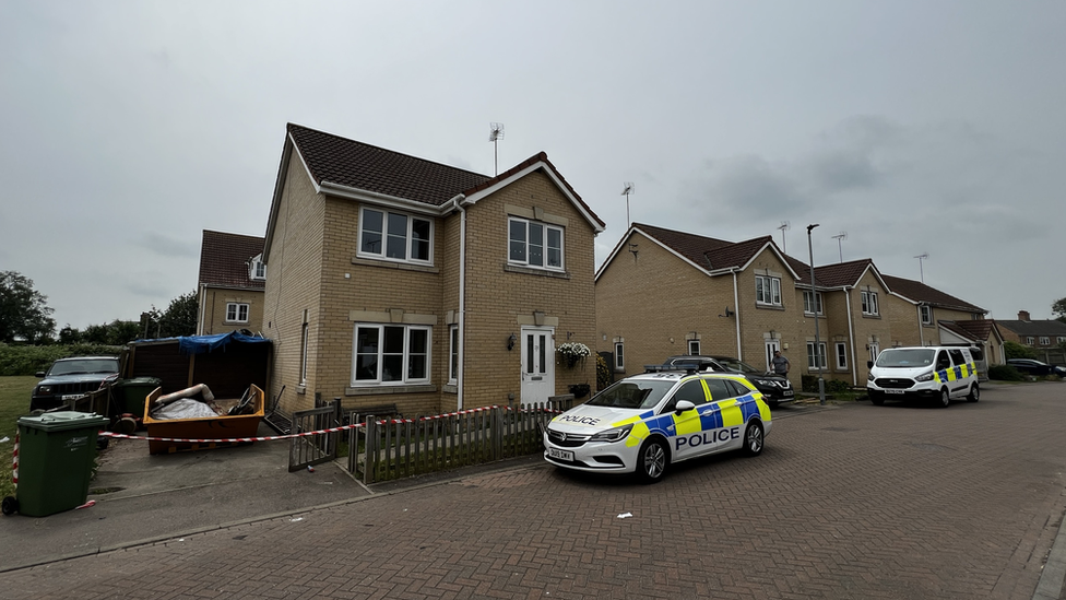 House with two police cars outside