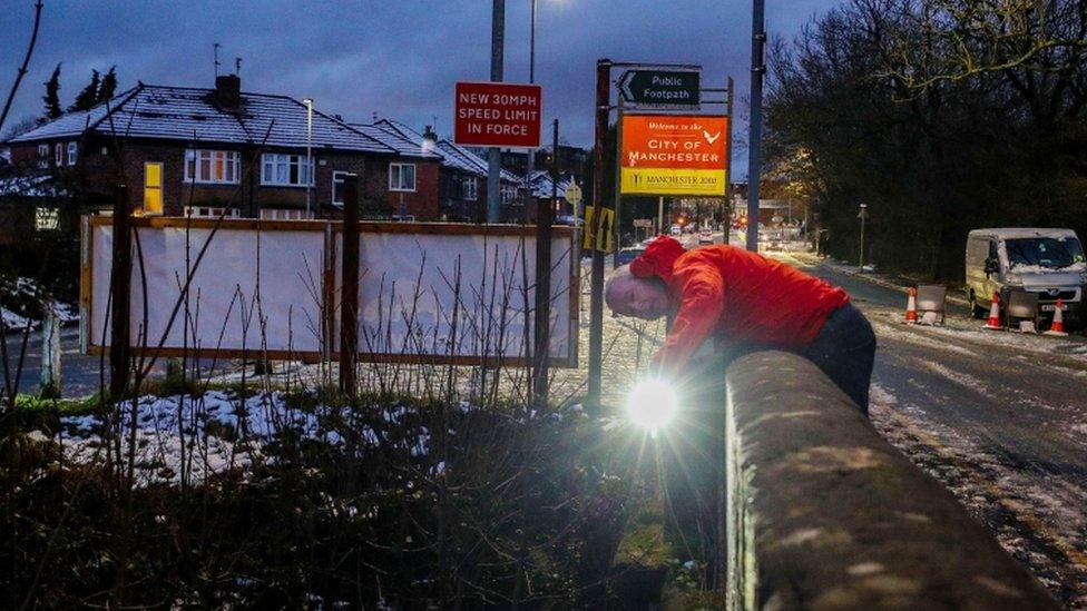 A council worker in Didsbury, Manchester, checks a bridge over the River Mersey for damage after heavy rainfall.