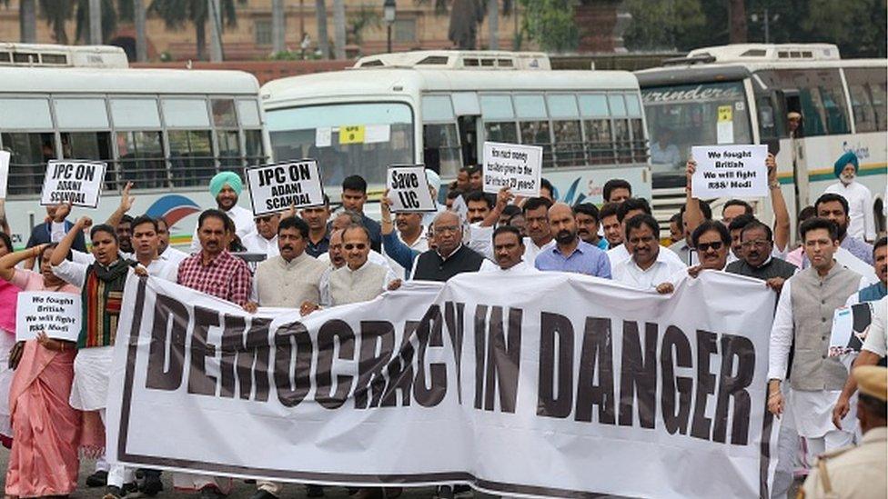 Congress party president Mallikarjun Kharge (C) along with members of parliamentof various opposition parties take part in a protest march