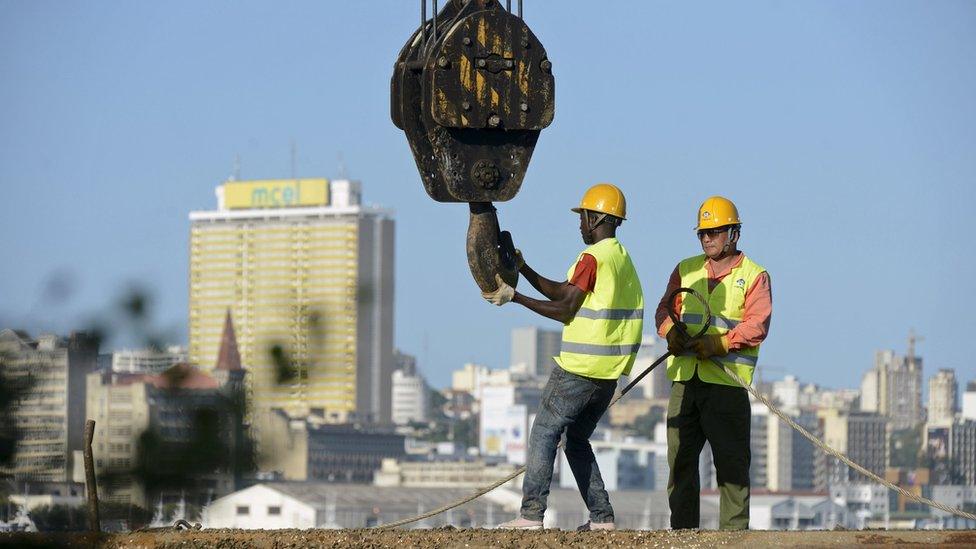 Construction workers build a new bridge against the skyline of Mozambique's capital Maputo April 15, 2016.