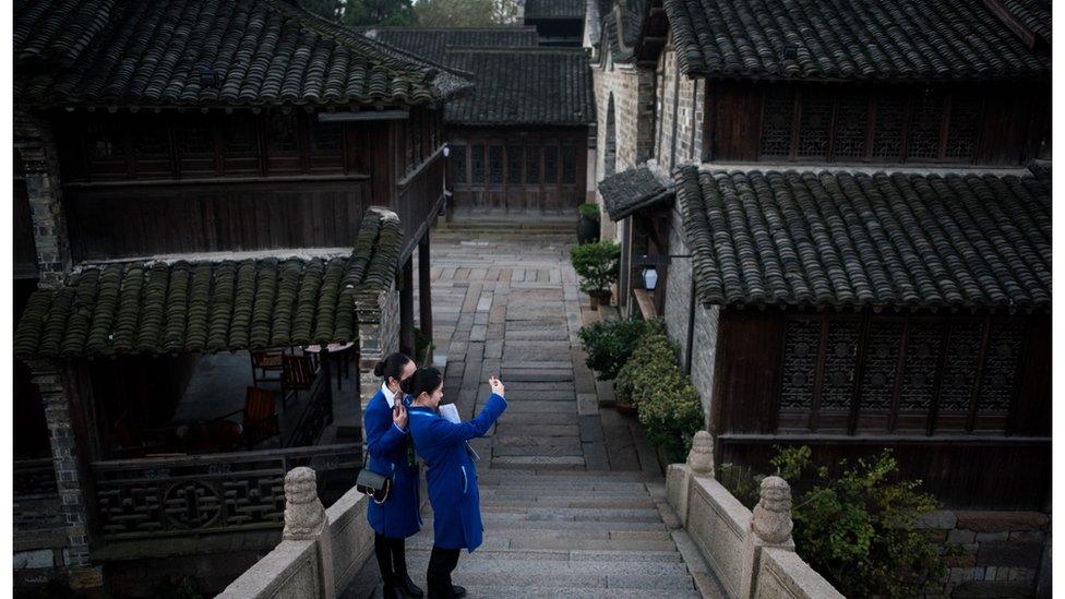 Two women take a selfie on a bridge in Wuzhen