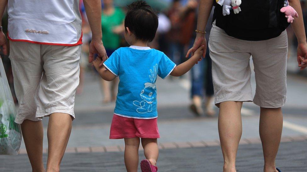 File photo: A Chinese family walking on a pavement