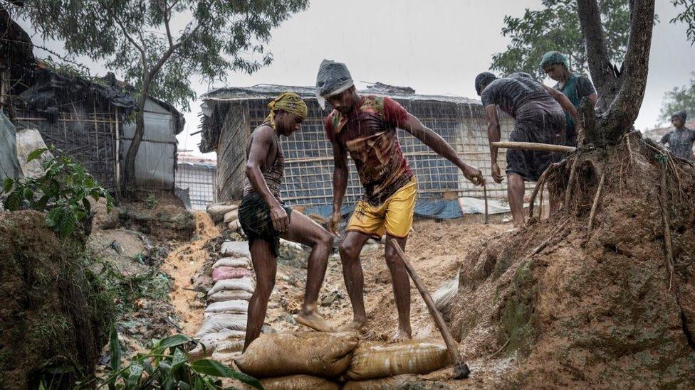 Men laying down sand bags