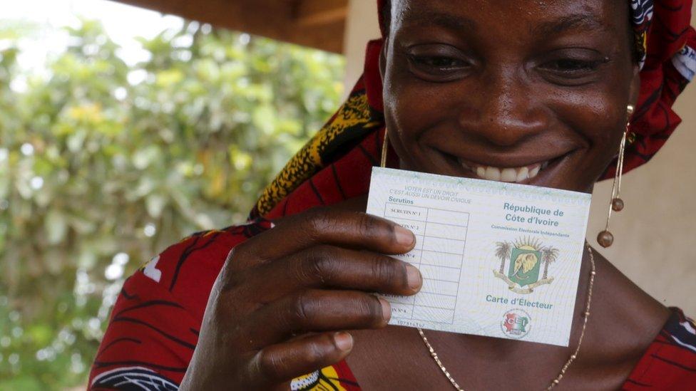 A woman smiles as she received her electoral card in Bingerville district, Abidjan