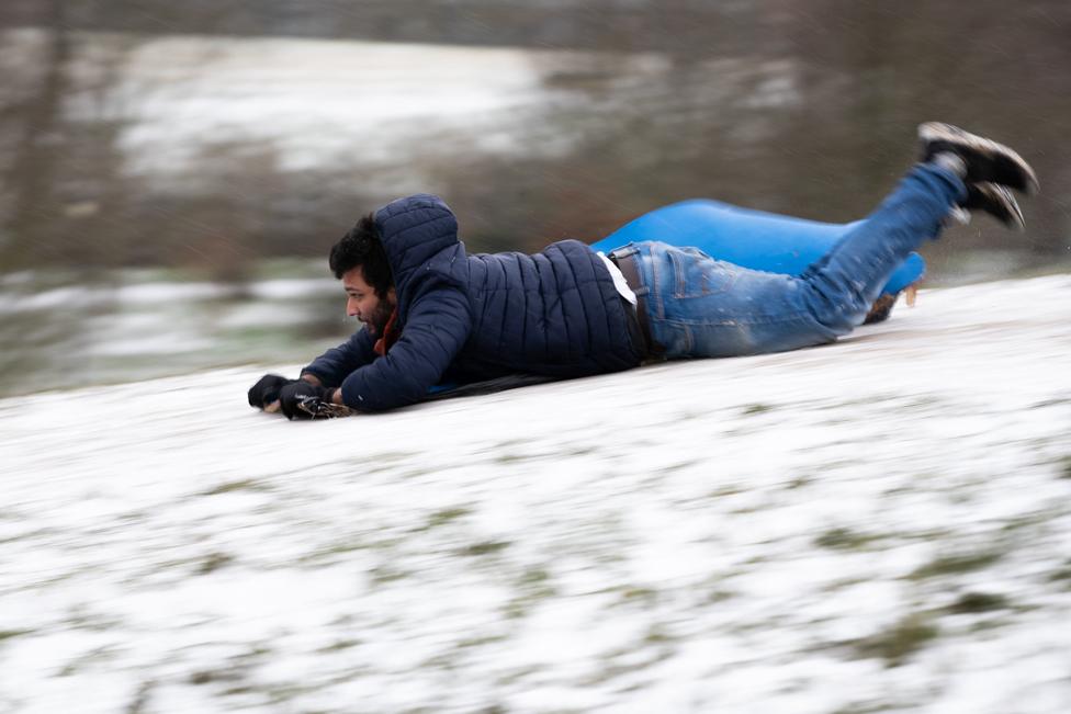 A man sleds down Primrose Hill in London, on 8 February 2021