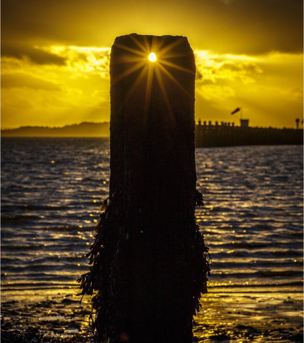 Sunset through harbour posts