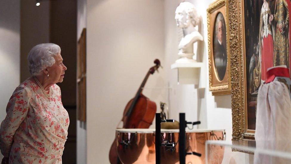 The Queen looks at an exhibit in Buckingham Palace