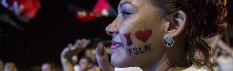 A woman has a "I love FSLN" painted on her cheek in Managua.