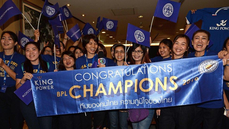 Leicester City fans cheer and wave flags as players arrive at Suvarnabhumi Airport in Bangkok (18 May 2016)