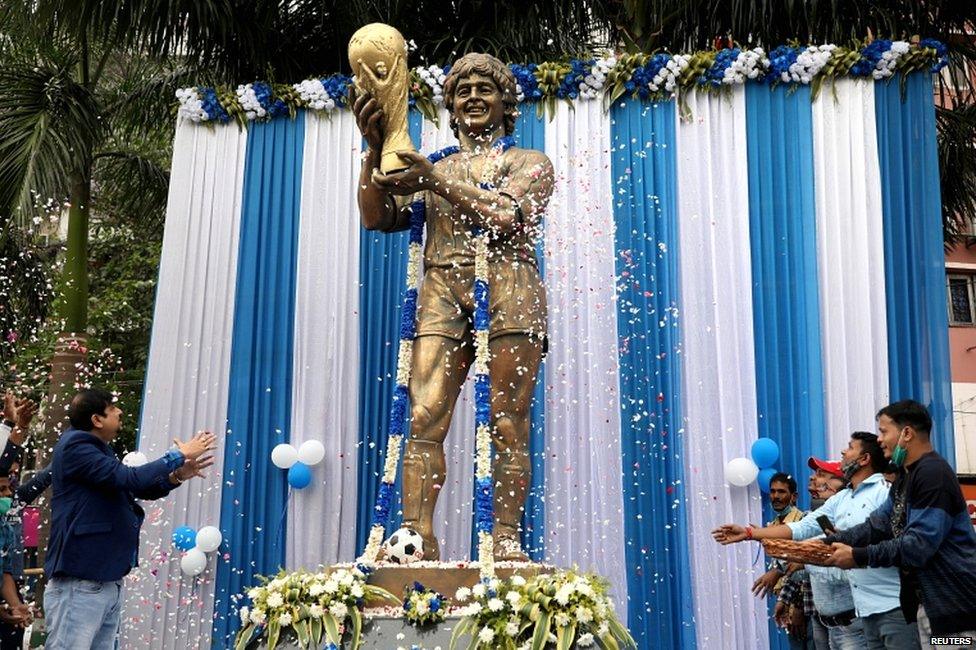 People shower petals on a statue of Argentine soccer great Diego Maradona during a prayer meeting to pay tribute to the player, in Kolkata, India, on 26 November 2020