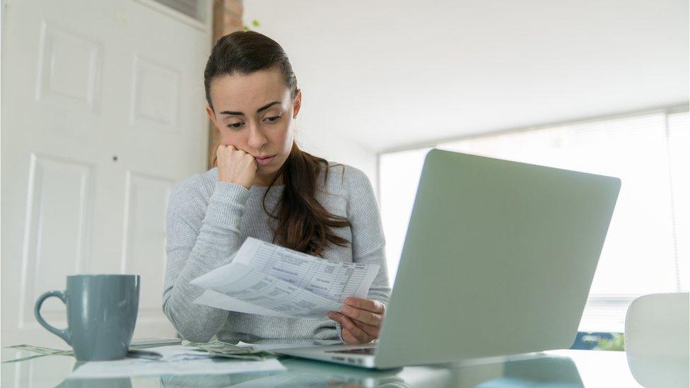 Woman looks at utility bills - stock shot