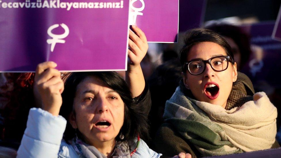 Turkish female protesters shout slogans against the government as they hold placards reading "Rape cannot be legalised