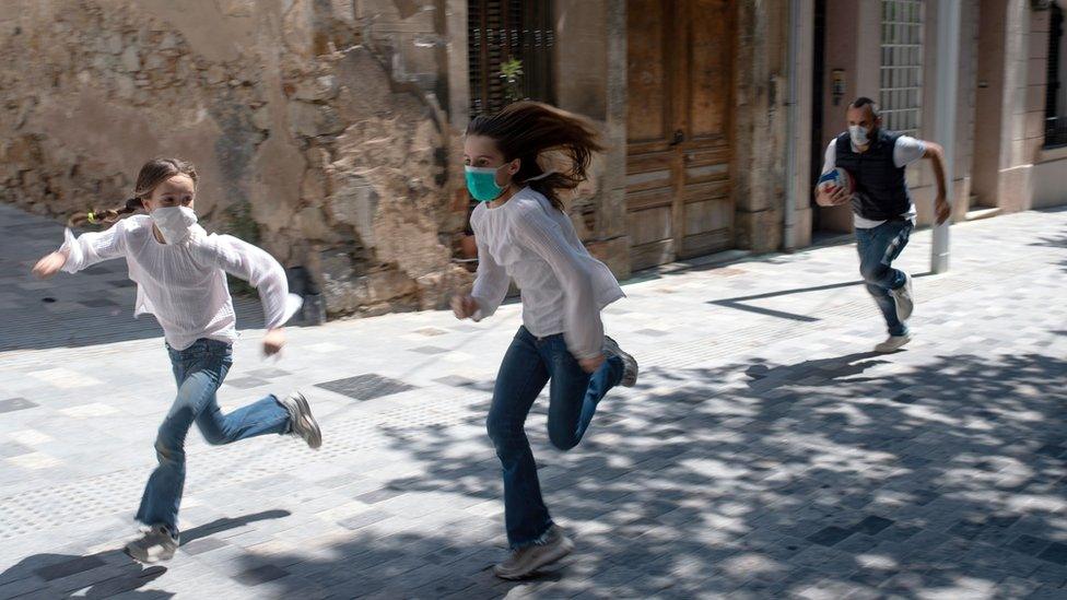 Joan, 45, chases his daughters Ines, 11, and Mar, 9, as they play in the street on April 26, 2020, in Barcelona, during a national lockdown to prevent the spread of the COVID-19 disease