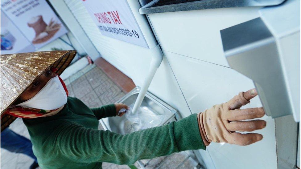 A woman keys in her details to collect rice from a "rice ATM".