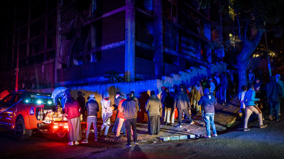 Residents of the derelict San Jose building in Johannesburg stand in line waiting to receive their share of bread, tinned food and a blanket from the Muslim Association of South Africa