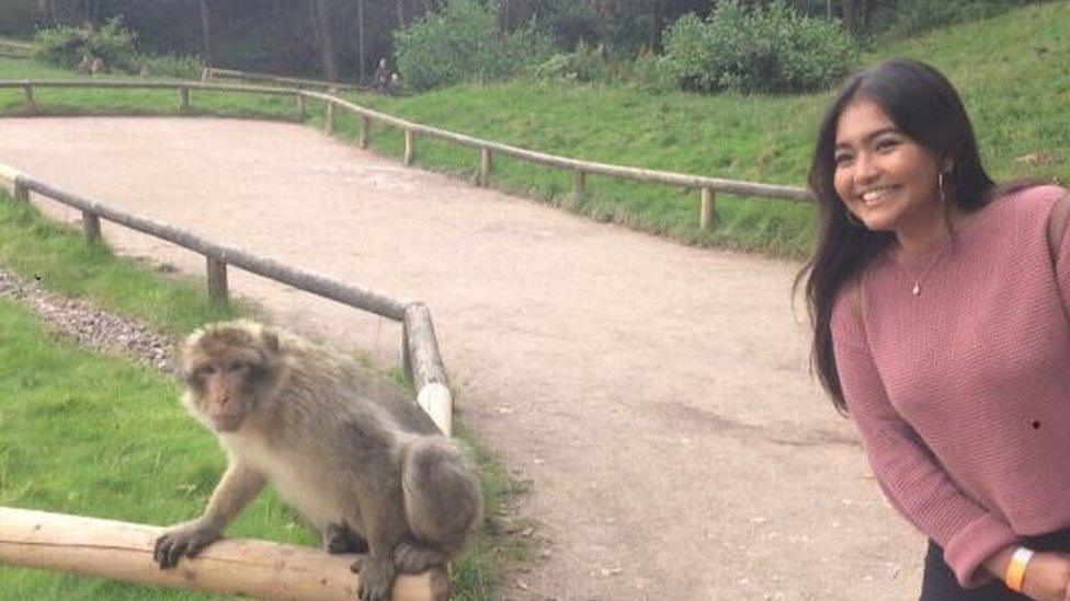 Woman posing for a photo with a monkey