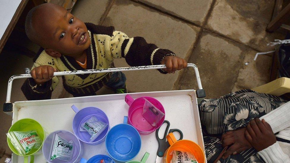 Boy stands next to medicine tray