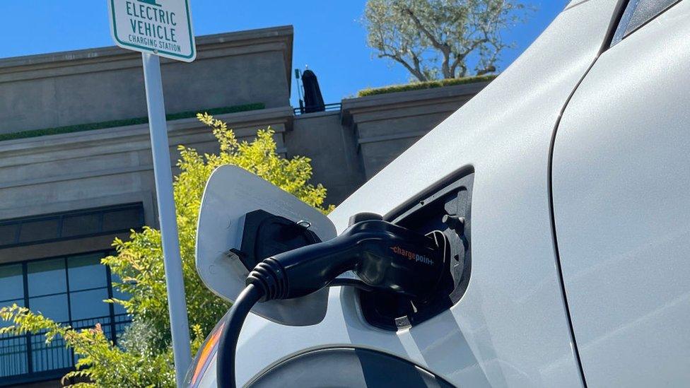 An electric car charges at a parking lot in California.