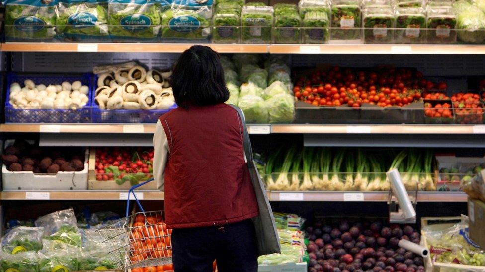 A customer looks at vegetables on display at a farm shop in Cambridgeshire