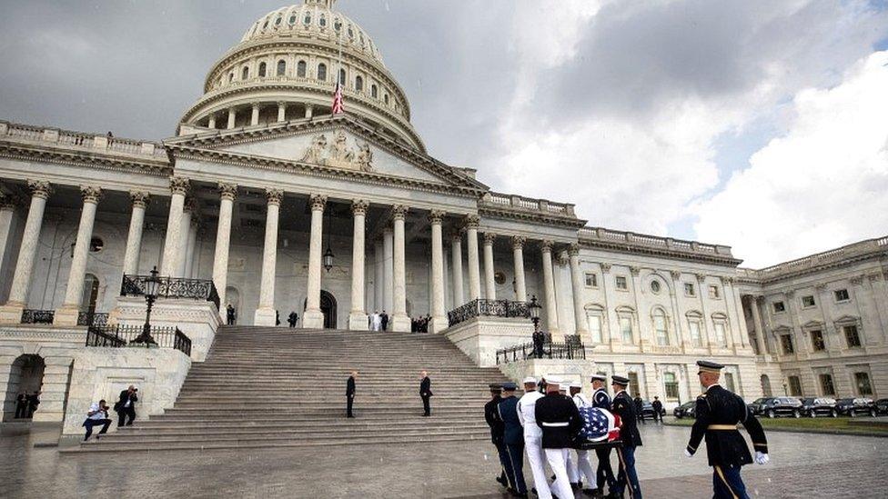 Joint service members of a military casket team prepare carry the casket of US Senator John McCain into the US Capitol, where he will lie in state for the rest of the day in Washington on 31 August 2018