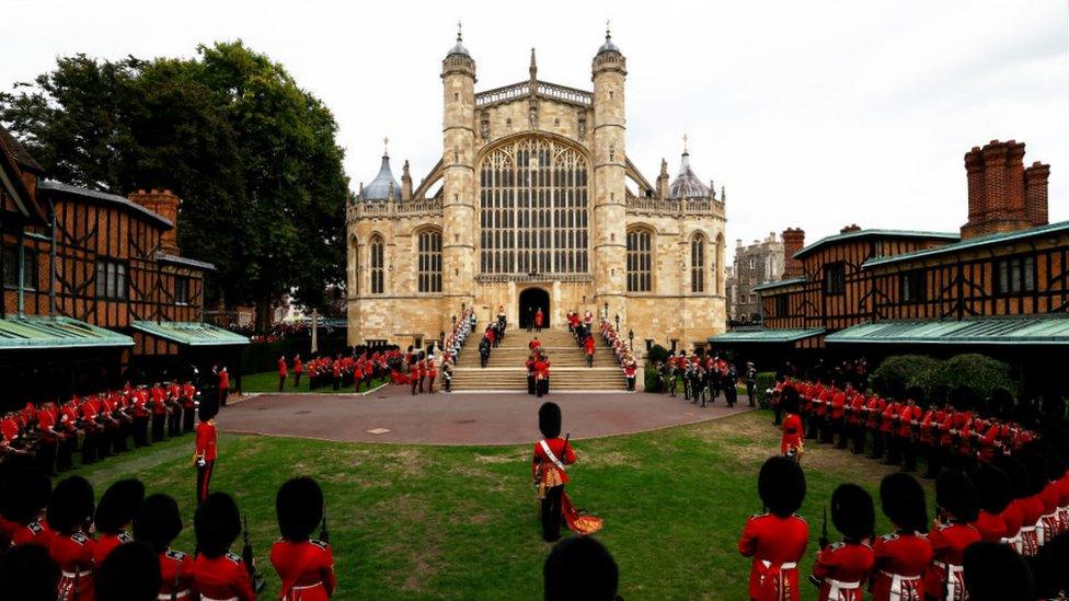 st george's chapel with guards looking on as pall bearers carry the coffin up the chapel steps